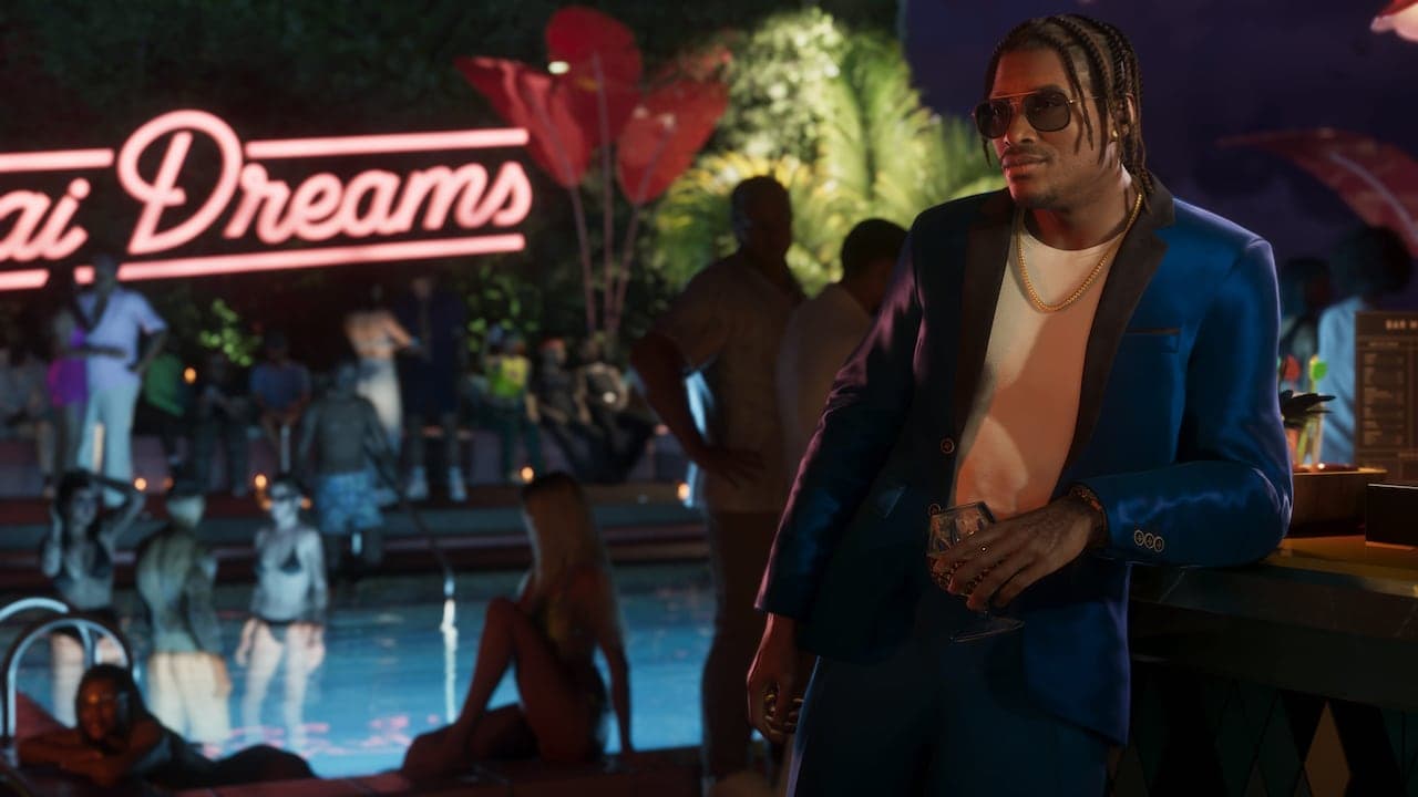 Dre'Quan in a blue suit at a poolside party at night, a drink in his hand.
