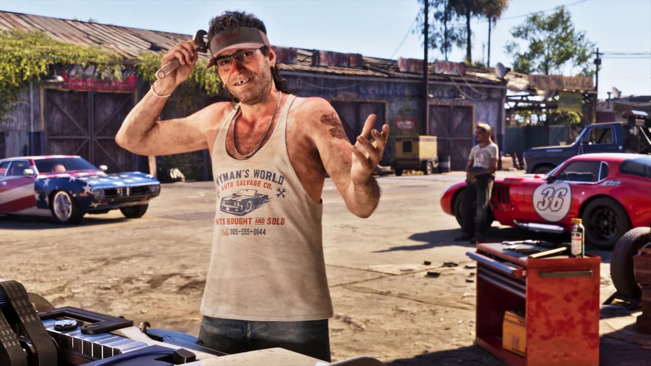 Wyman outside a garage in a visor, glasses and a vest printed "Wyman's World Auto Salvage Co.", raising a wrench, with classic cars parked behind him.