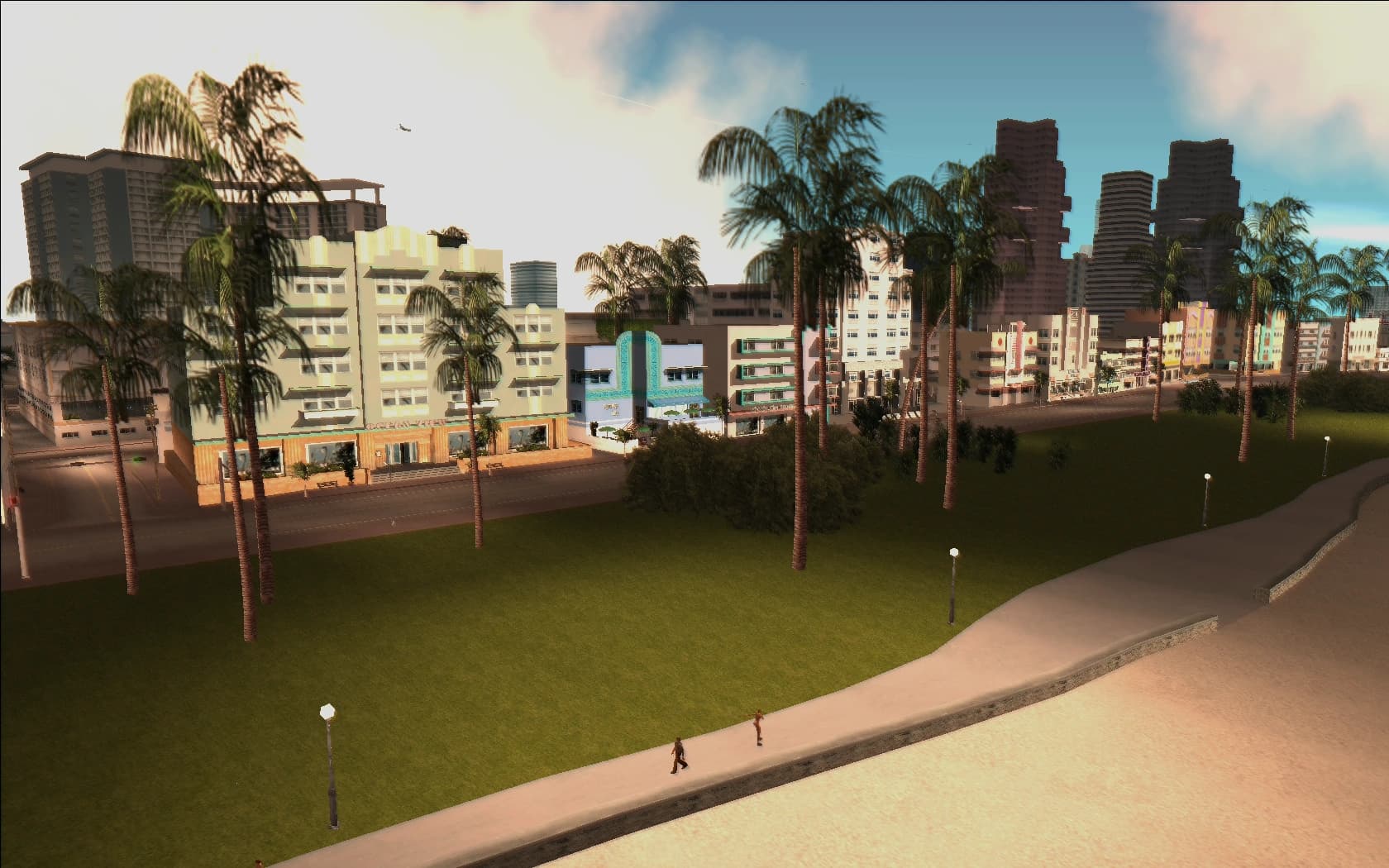 Ocean Beach in 1986, pastel art deco hotels along the seafront with palms and wide sand in front of them.