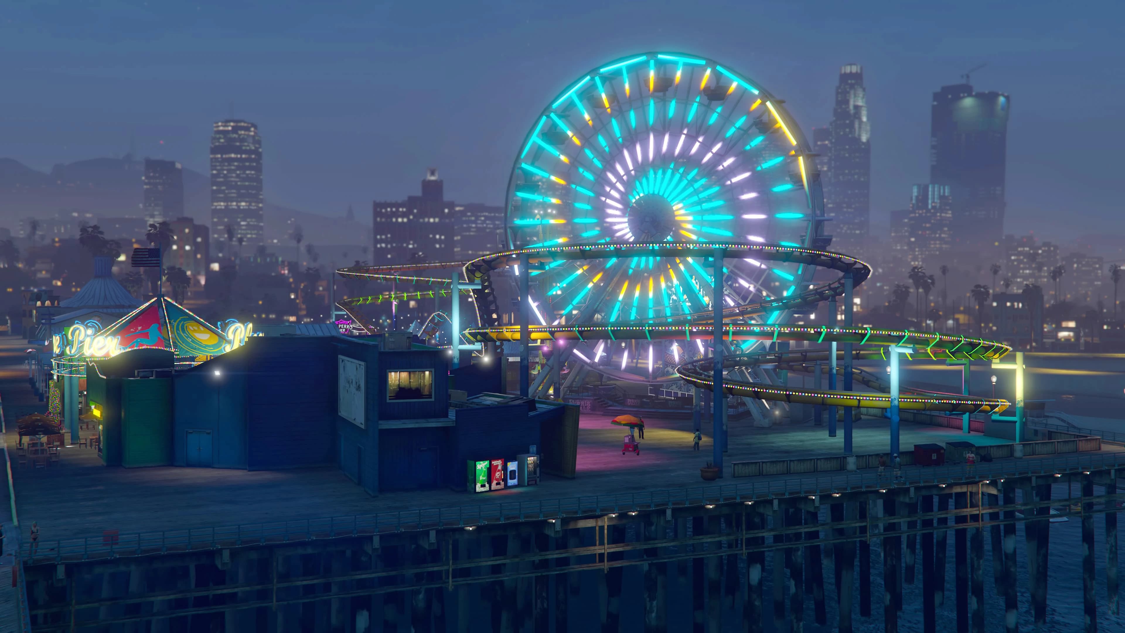 Del Perro Pier at dusk, its ferris wheel and rollercoaster lit in cyan and yellow neon with the Los Santos skyline behind.