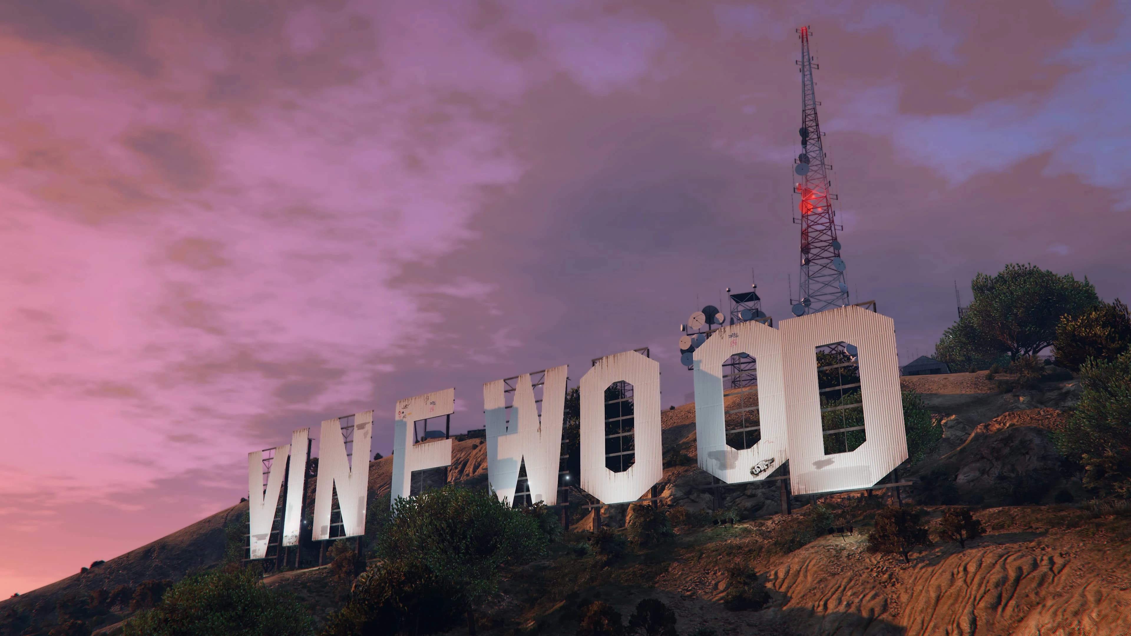Vinewood Hills at dusk, houses scattered along the ridges above the city.