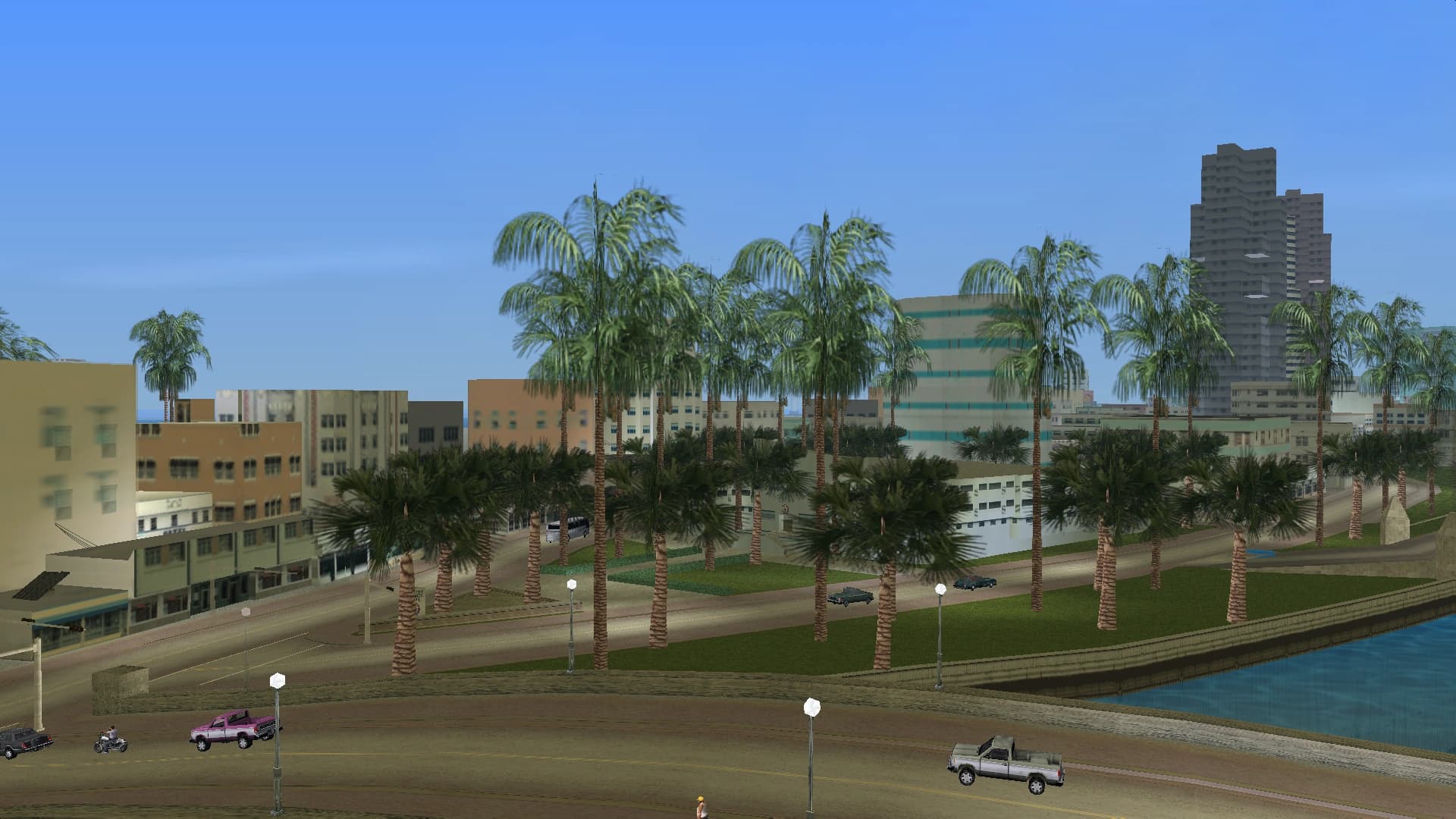 Washington Beach's seafront boulevard, palms along the road between the blocks and the water.