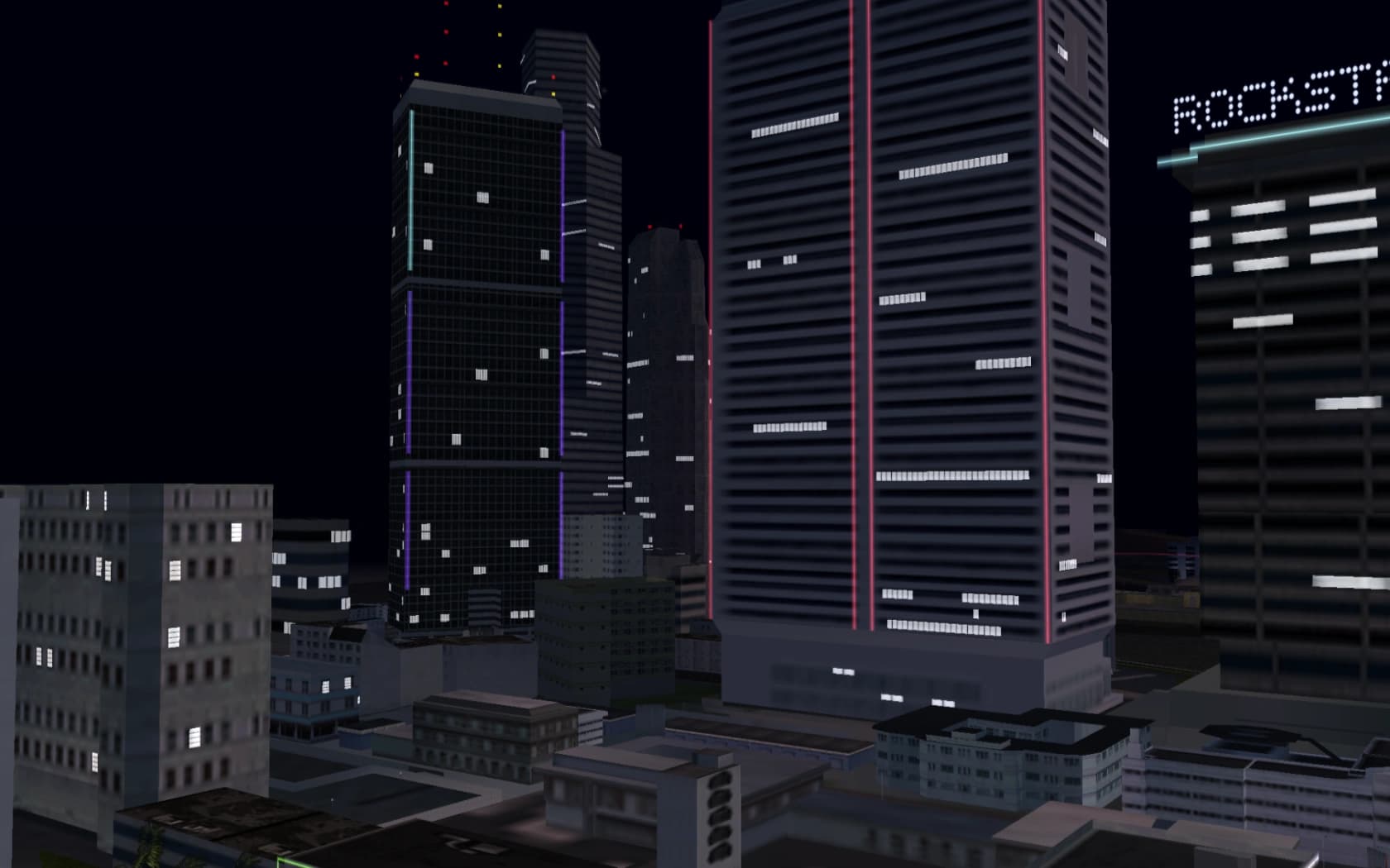 Downtown Vice City at night, floodlit towers rising over the surrounding blocks.