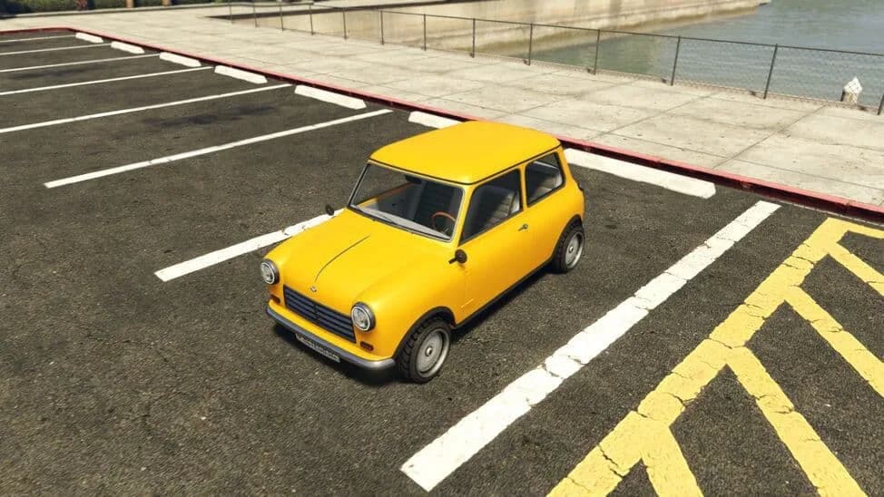 The Weeny Issi Classic, a yellow 1960s two-door city car, parked in a car park by the water, in GTA Online.