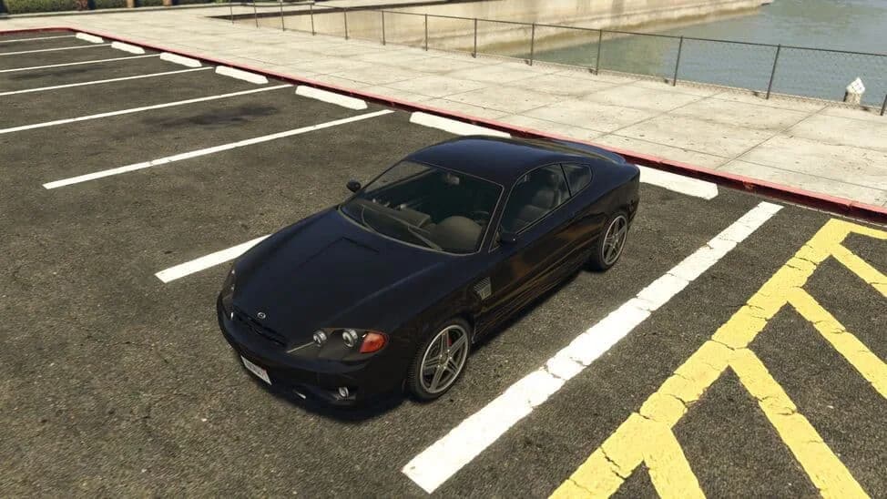 The Bollokan Prairie, a black compact sports coupe, parked in a car park by the water, in GTA Online.