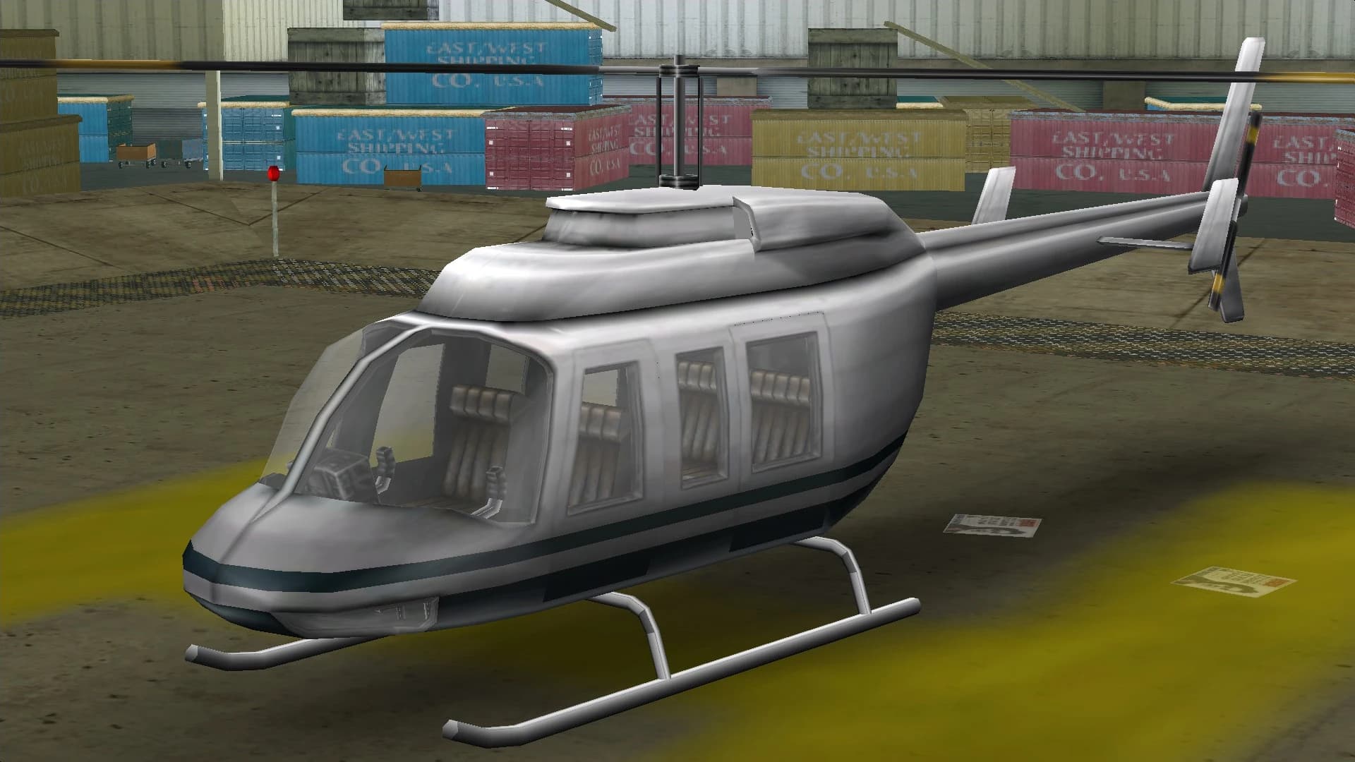A white and grey Maverick helicopter, on a helipad.