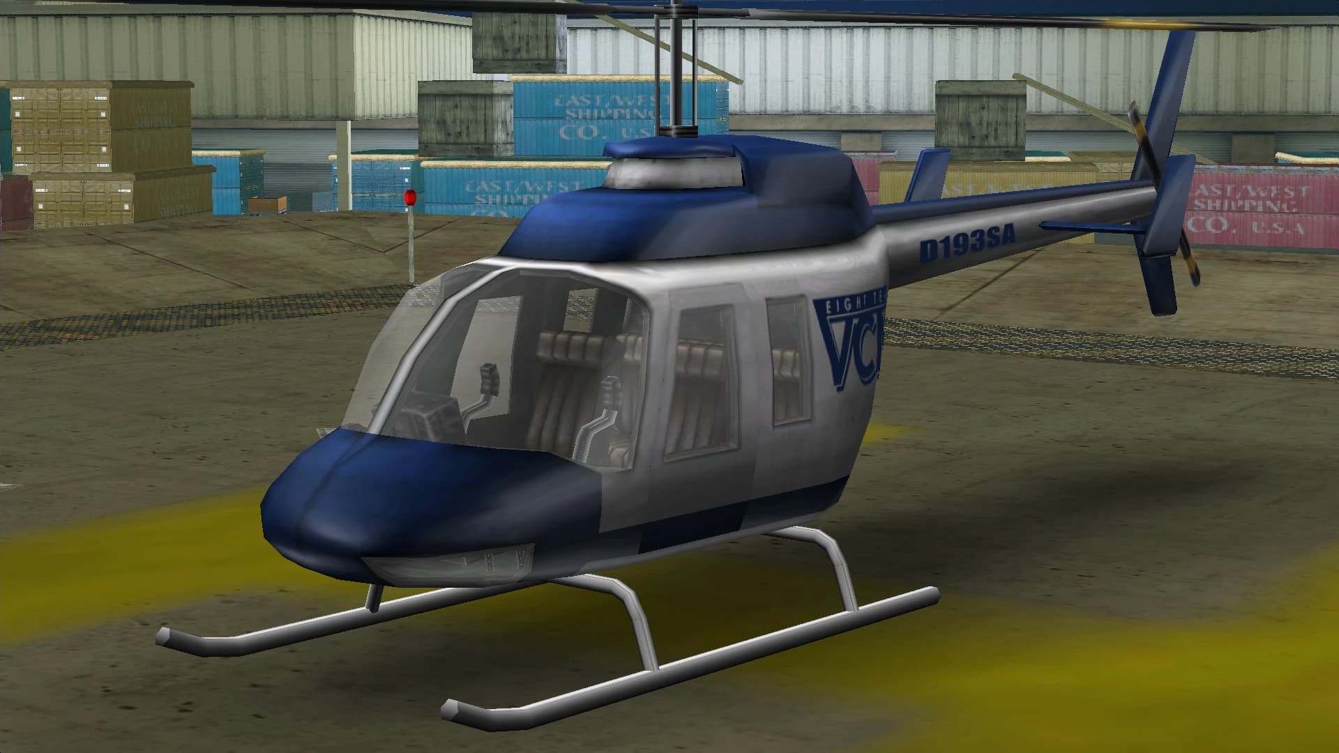 A blue and white VCN Maverick news helicopter, on a helipad.