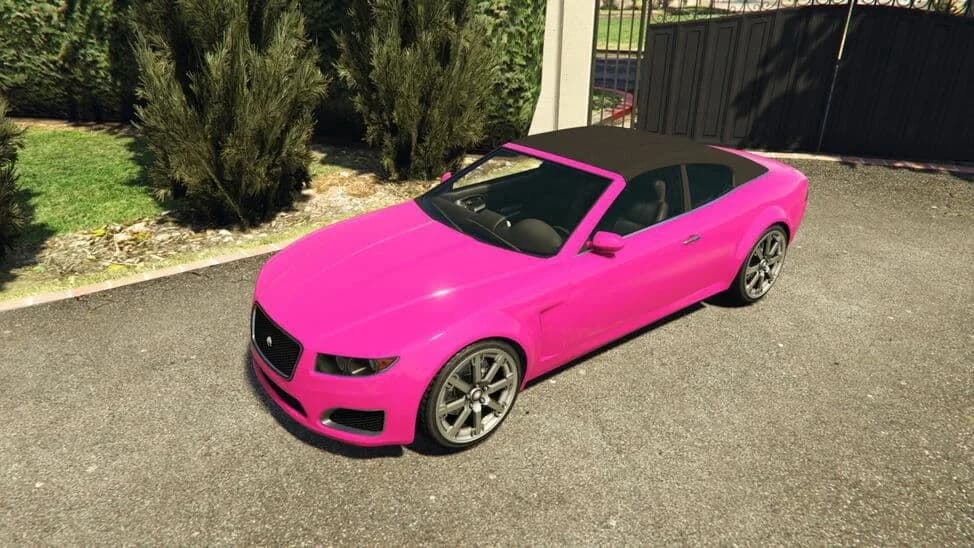 The Lampadati Felon GT, a pink convertible coupe with its black soft top raised, parked by a driveway, in GTA Online.