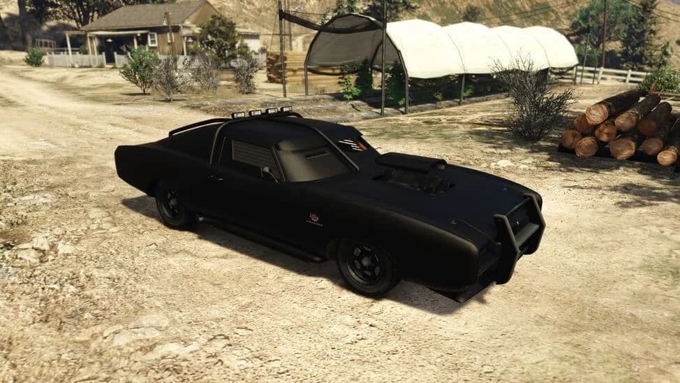 The Imponte Duke O'Death, a black armoured muscle car with a ram bar and roof spikes, parked on a dirt yard, in GTA Online.