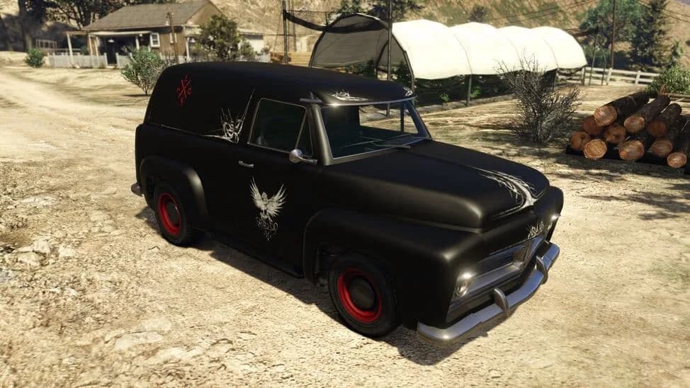 The Vapid Lost Slamvan, a black 1950s panel van with motorcycle-club artwork, parked on a dirt yard, in GTA Online.