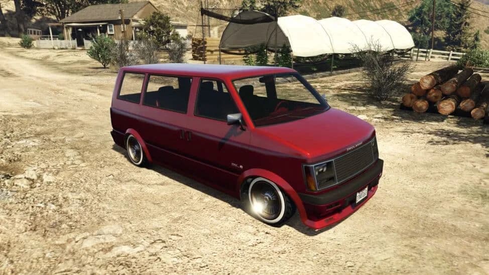 The Declasse Moonbeam Custom, a red lowered 1980s van on chrome wheels, parked on a dirt yard, in GTA Online.