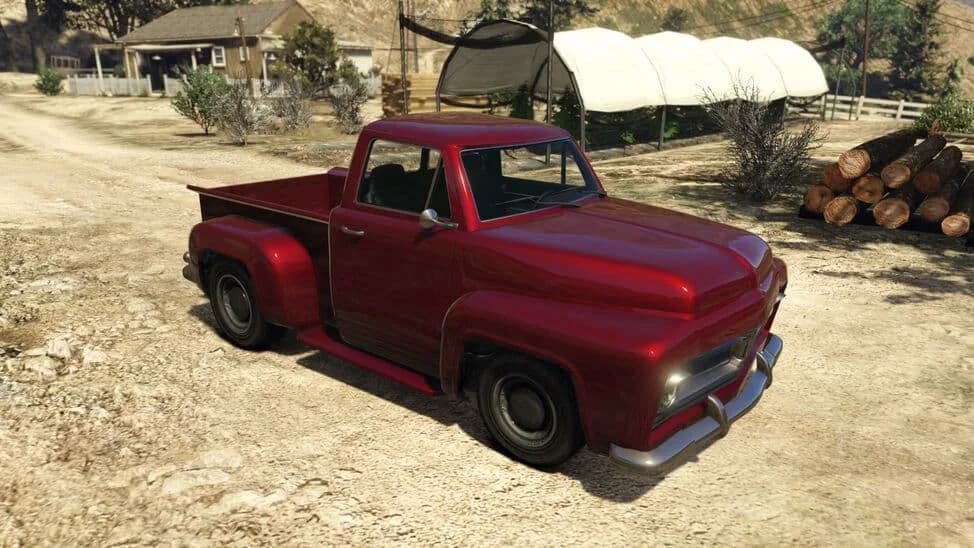 The Vapid Slamvan, a dark red 1950s-style pickup, parked on a dirt yard, in GTA Online.