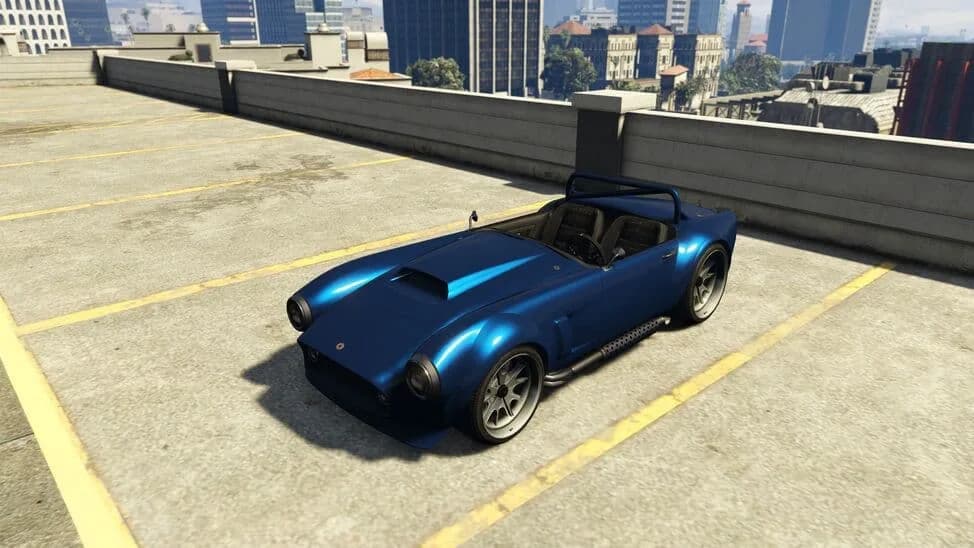 The Declasse Mamba, a blue 1960s open roadster with a roll bar, parked on a rooftop car park, in GTA Online.