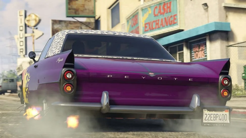 The Vapid Peyote Custom, a purple lowered late-1950s car with tail fins and a patterned roof, seen from the rear on a city street, in GTA Online.