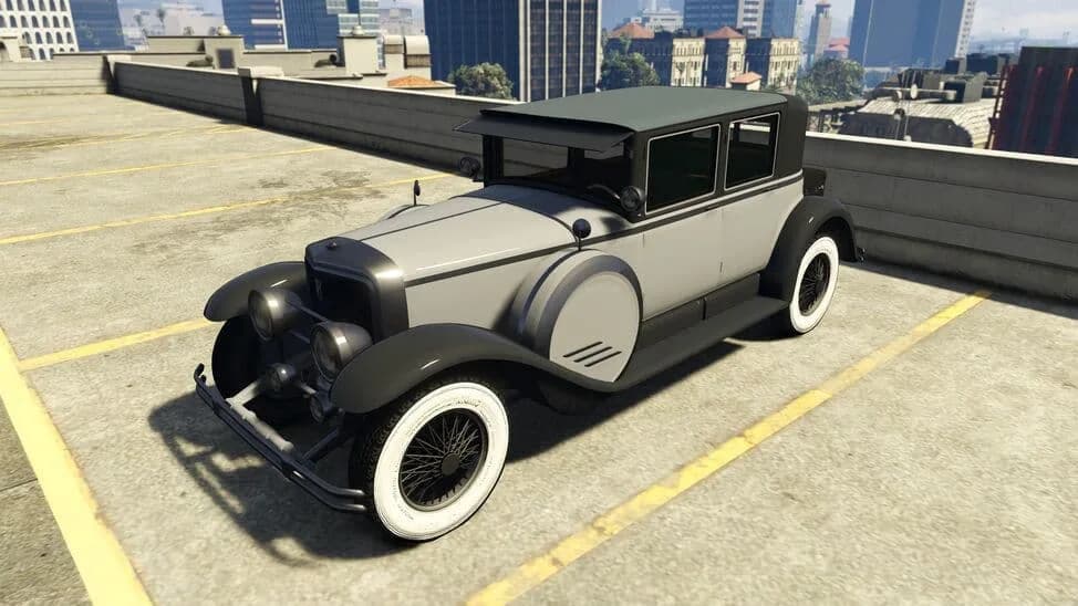 The Albany Roosevelt Valor, a grey and black 1920s limousine with whitewall tyres, parked on a rooftop car park, in GTA Online.