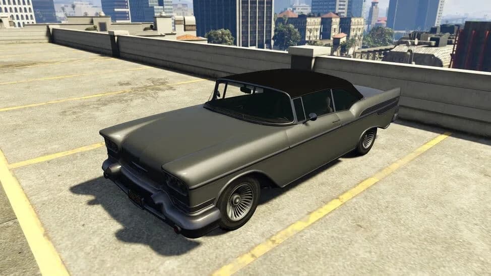 The Declasse Tornado Cabrio, a grey late-1950s convertible with its black roof raised, parked on a rooftop car park, in GTA Online.