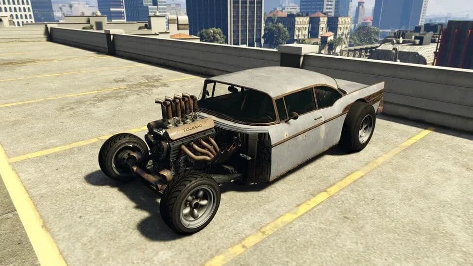 The Declasse Tornado Rat Rod, a weathered classic rat rod with an exposed front engine and open front wheels, parked on a rooftop car park, in GTA Online.