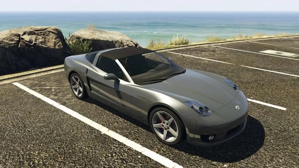 The Invetero Coquette D5, a grey 2000s front-engined sports car, parked by the coast, in GTA Online.