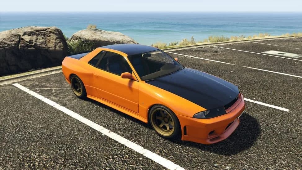 The Annis Elegy Retro Custom, an orange 1990s sports coupe with a black bonnet, parked by the coast, in GTA Online.