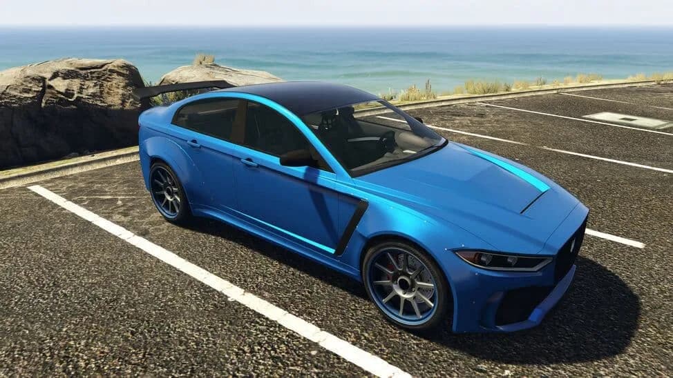 The Ocelot Jugular, a blue four-door sports saloon with a rear wing, parked by the coast, in GTA Online.