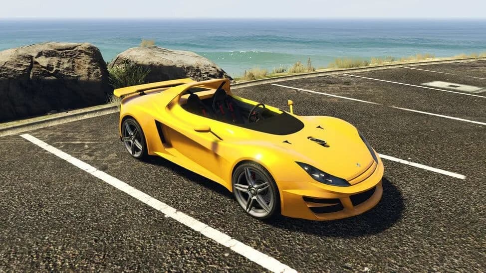 The Ocelot Locust, a yellow open-top lightweight sports car, parked by the coast, in GTA Online.