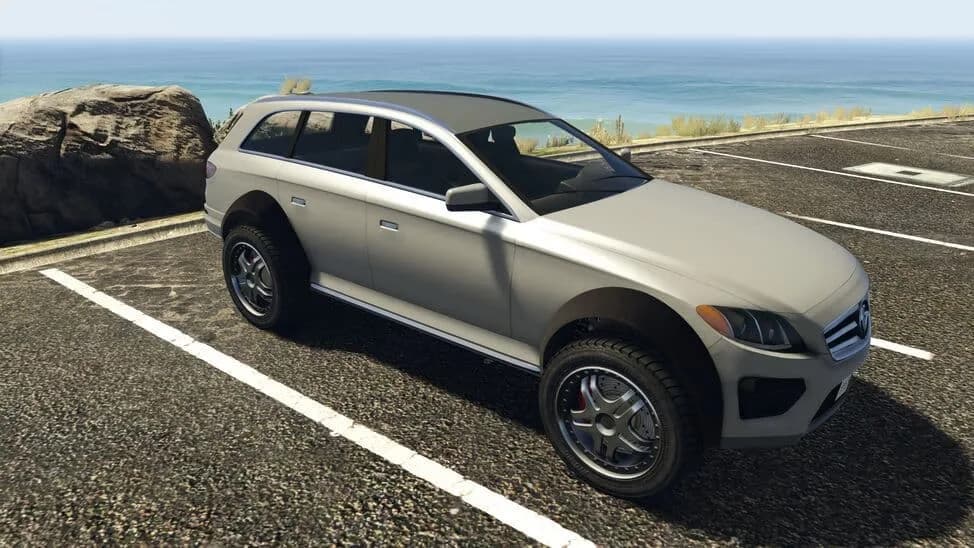 The Benefactor Streiter, a silver raised performance estate on chunky tyres, parked by the coast, in GTA Online.