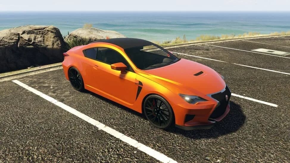 The Emperor Vectre, an orange sports coupe with a black roof, parked by the coast, in GTA Online.