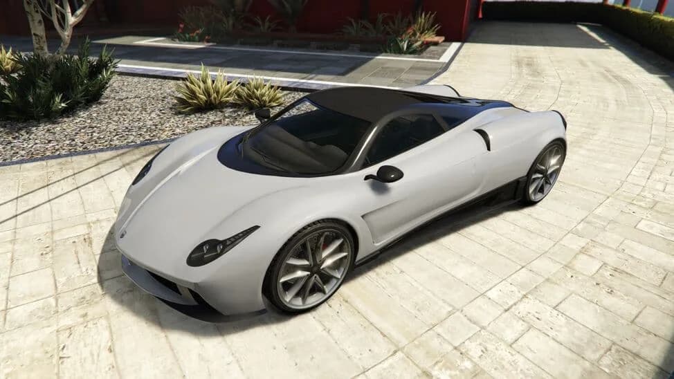 The Pegassi Osiris, a white supercar with a black roof, parked on a paved courtyard, in GTA Online.