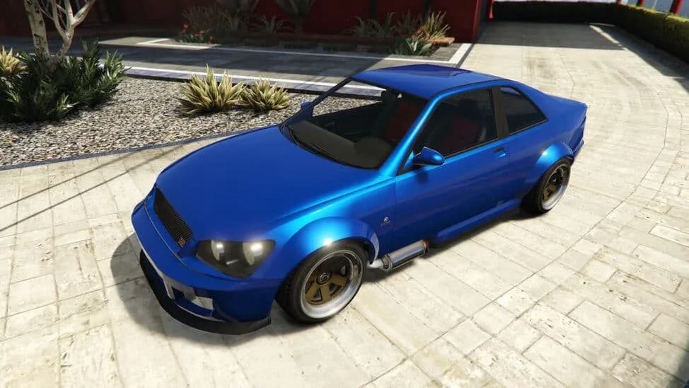 The Karin Sultan RS, a blue widebody four-door sports saloon, parked on a paved courtyard, in GTA Online.