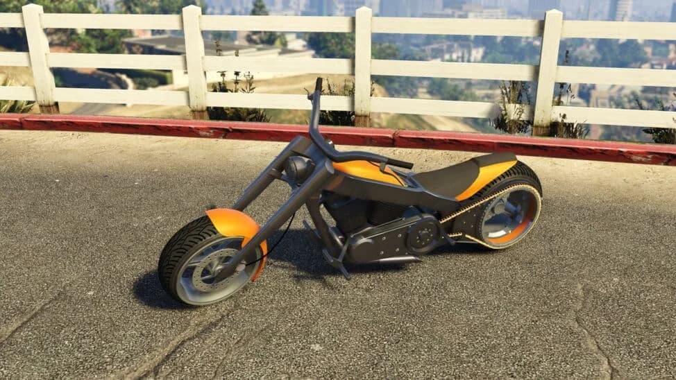 The LCC Innovation, a black and orange custom chopper with hubless-style wheels, parked by a white fence, in GTA Online.