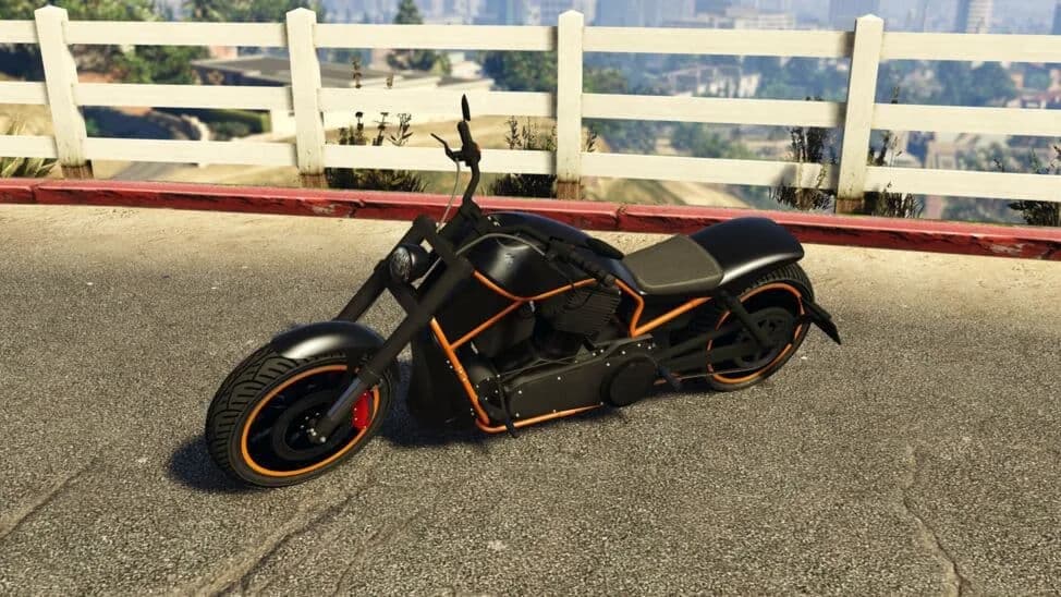 The Western Nightblade, a black and orange low cruiser motorcycle, parked by a white fence, in GTA Online.