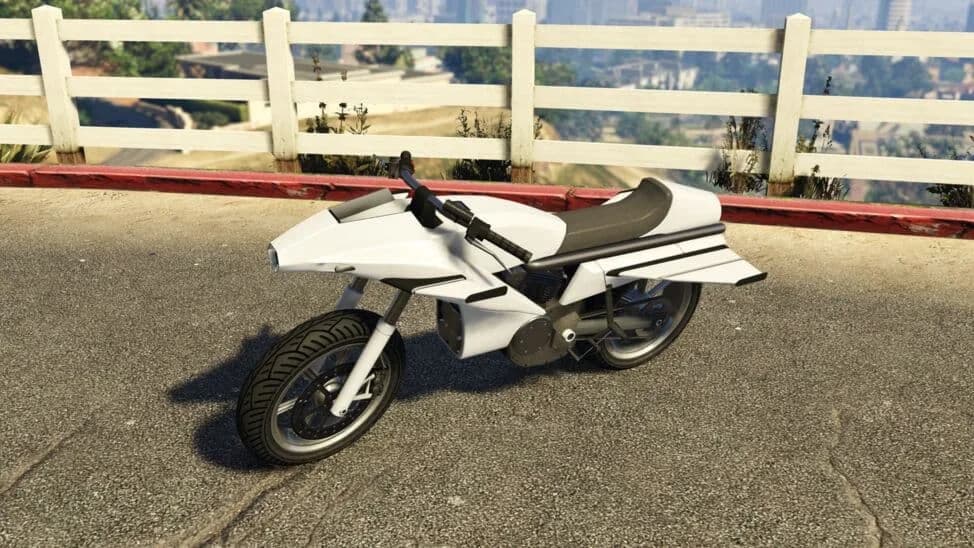 The Pegassi Oppressor, a white motorcycle with fold-out wings, parked by a white fence, in GTA Online.