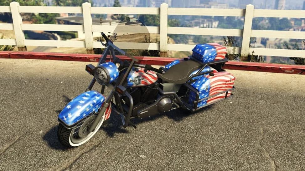 The Western Sovereign, a touring motorcycle in stars-and-stripes paint, parked by a white fence, in GTA Online.