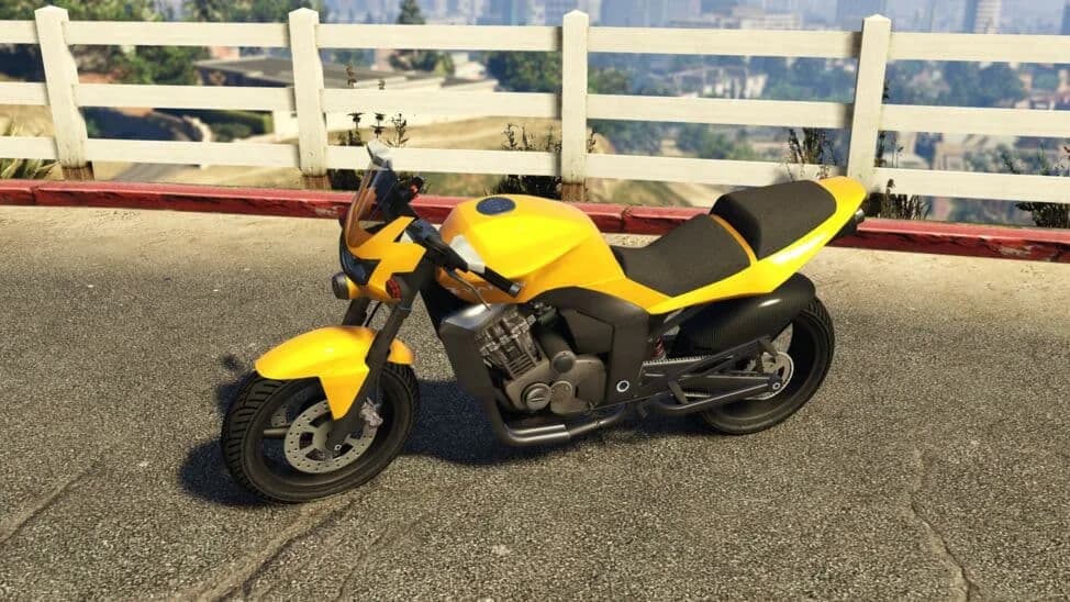 The Shitzu Vader, a yellow naked street motorcycle, parked by a white fence, in GTA Online.
