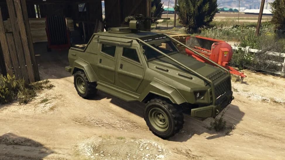 The HVY Insurgent Pick-Up, an olive armoured truck with a roof-mounted machine gun and roll bar, parked by a barn, in GTA Online.
