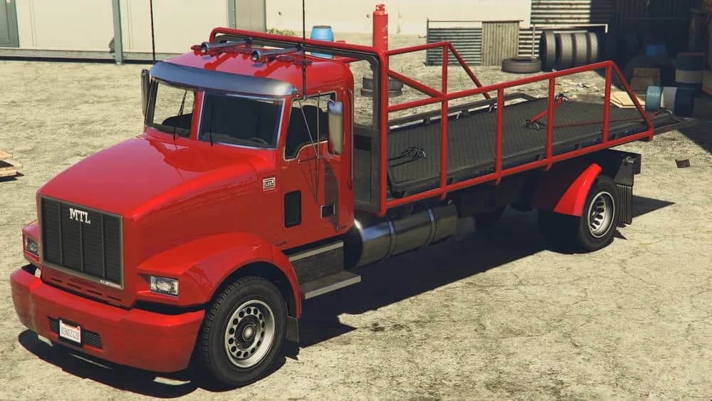 The MTL Custom Flatbed, a red flatbed truck with a cargo cage, parked in a builder's yard, in GTA Online.