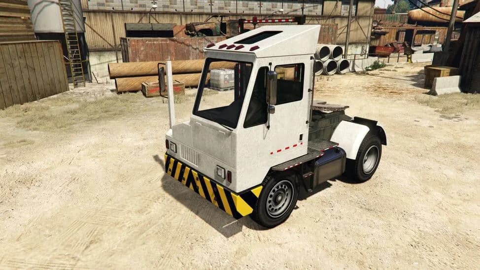 The Docktug, a white yard tractor with hazard stripes, parked in a dock yard, in GTA Online.