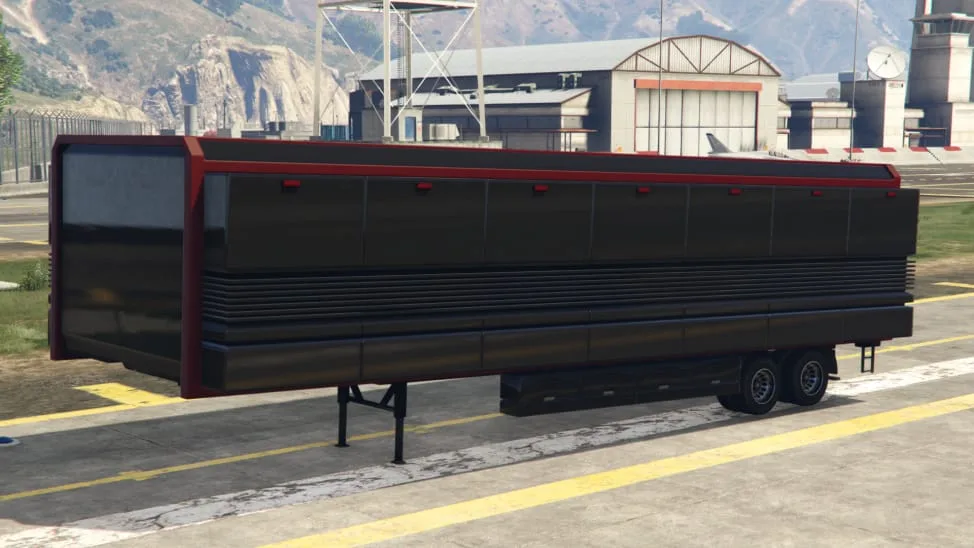 The Mobile Operations Center, a long black trailer with red trim, parked on an airfield apron, in GTA Online.