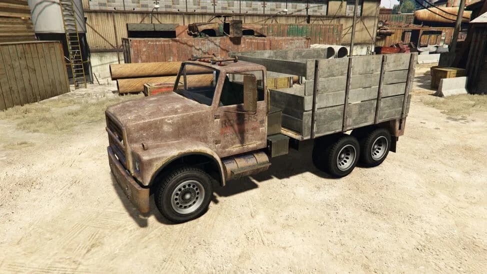 The Scrap Truck, a rusted flatbed lorry with wooden side boards, parked in a yard, in GTA Online.
