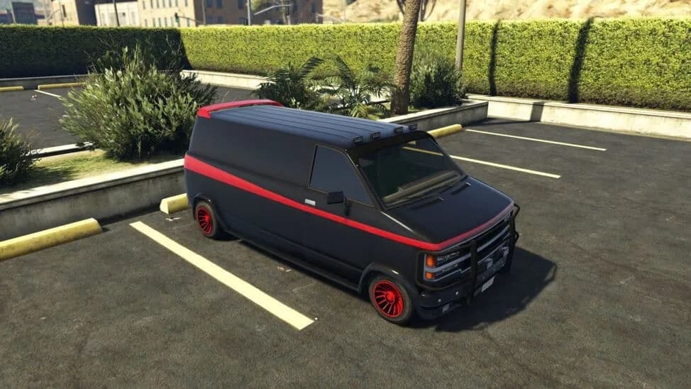 The Declasse Gang Burrito (Custom), a black van with a red side stripe, red wheels and a front bull bar, parked in a car park, in GTA Online.