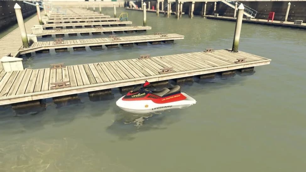 The Speedophile Seashark Lifeguard, a red and white personal watercraft in lifeguard livery, floating by a jetty, in GTA Online.