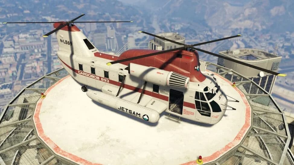 The Cargobob (Jetsam), a white and red twin-rotor transport helicopter in a cargo-company livery, parked on a rooftop helipad above the city, in GTA Online.