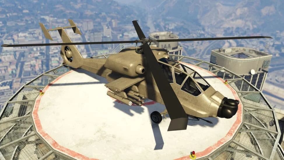The FH-1 Hunter, a tan attack helicopter with stub-wing weapons, parked on a rooftop helipad above the city, in GTA Online.