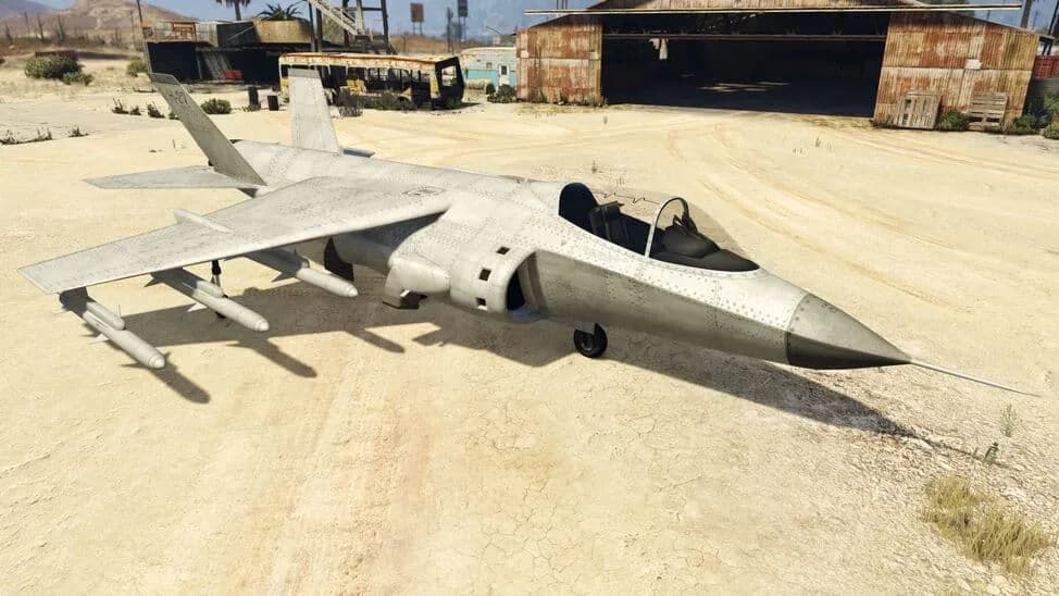 The Mammoth Hydra, a grey vertical take-off jet fighter with underwing missiles, parked on a desert airfield, in GTA Online.