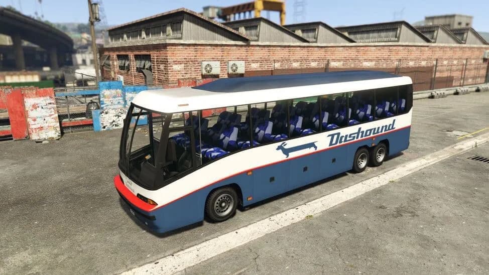 The Dashound, a blue and white long-distance coach, parked by a brick warehouse, in GTA Online.
