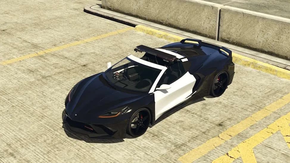 The Invetero Coquette D10 Pursuit, a black and white police sports car with a light bar, parked on a rooftop car park, in GTA Online.