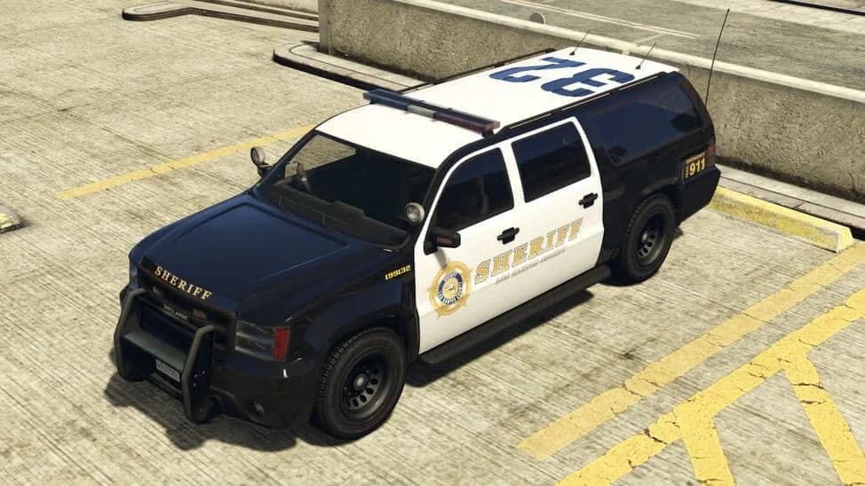 The Sheriff SUV, a black and white sheriff's patrol SUV with a light bar, parked on a rooftop car park, in GTA Online.