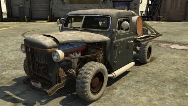 A rusty bare-metal Rat-Loader hot rod truck standing in a yard, front three-quarter view.