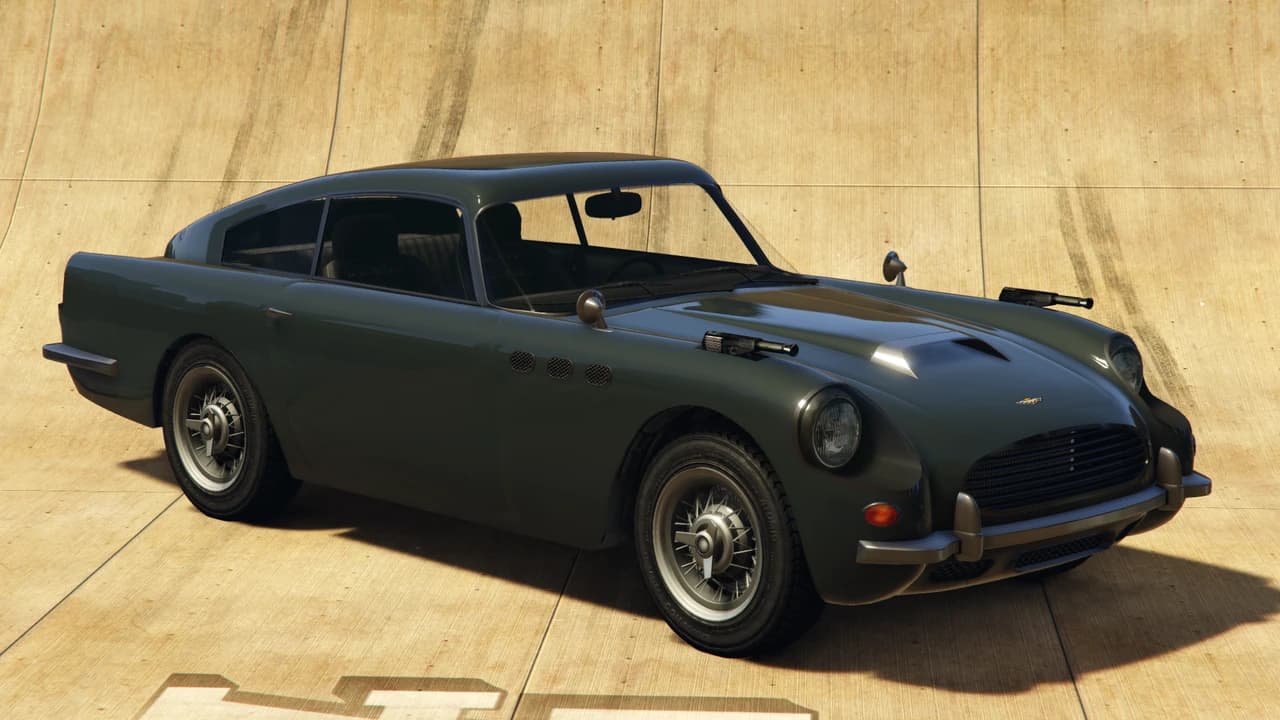 A dark green Dewbauchee JB 700 with front-mounted guns, front three-quarter view.