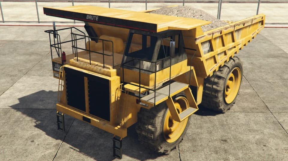 A yellow mining dump truck loaded with rubble, front three-quarter view.